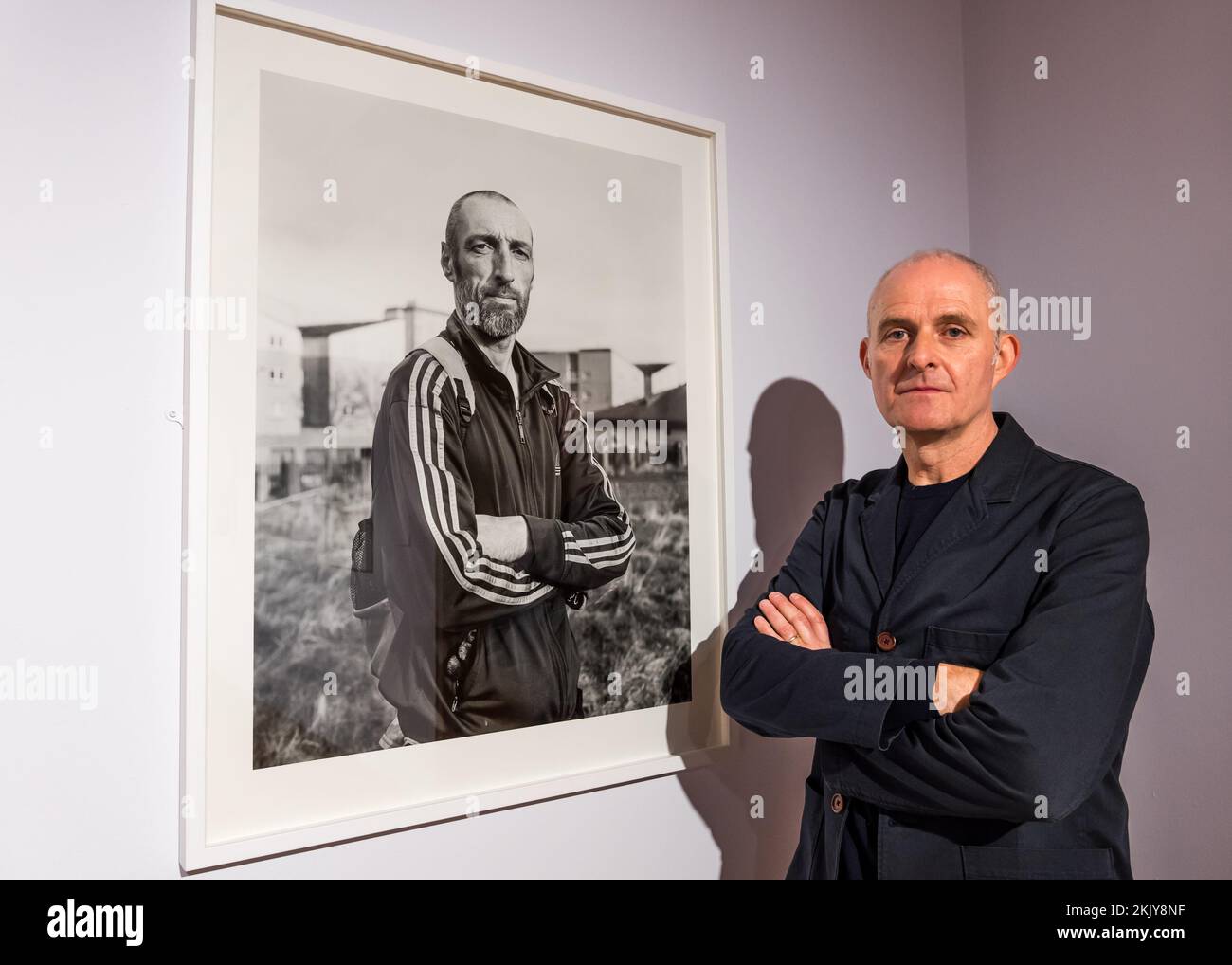 City Art Centre, Edimburgo, Scozia, Regno Unito, 25 novembre 2022, Nuova mostra fotografica: Apertura domani ‘No Ruined Stone’ presenta 38 fotografie in bianco e nero su larga scala che documentano l’ambiente costruito e i residenti di Muirhouse dal fotografo Paul Duke. Nella foto: Paul Duke con una delle sue fotografie. Credit: Sally Anderson/Alamy Live News Foto Stock