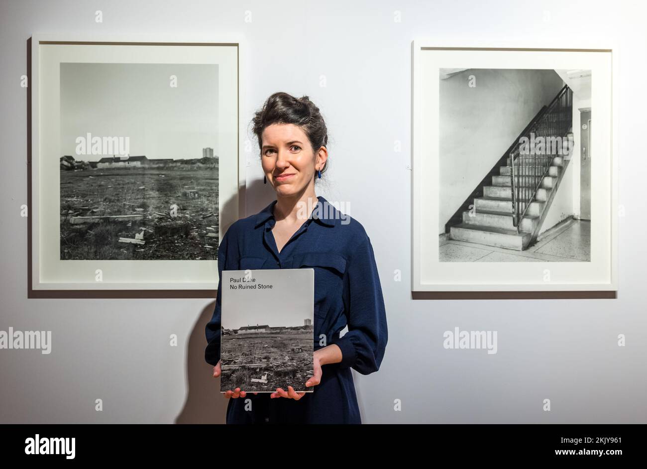 City Art Centre, Edimburgo, Scozia, Regno Unito, 25 novembre 2022, Nuova mostra fotografica: Apertura domani ‘No Ruined Stone’ presenta 38 fotografie in bianco e nero su larga scala che documentano l’ambiente costruito e i residenti di Muirhouse dal fotografo Paul Duke. Nella foto: Curatore Helen Scott con una delle fotografie presenti nel catalogo della mostra. Credit: Sally Anderson/Alamy Live News Foto Stock