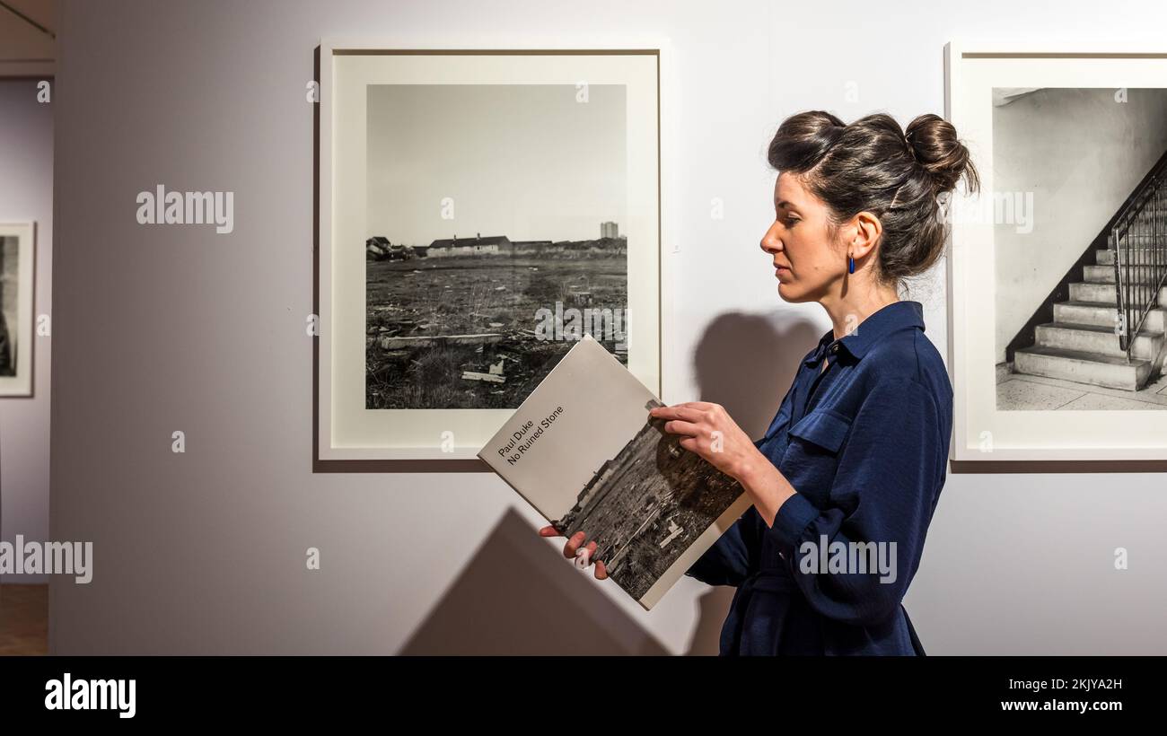 City Art Centre, Edimburgo, Scozia, Regno Unito, 25 novembre 2022, Nuova mostra fotografica: Apertura domani ‘No Ruined Stone’ presenta 38 fotografie in bianco e nero su larga scala che documentano l’ambiente costruito e i residenti di Muirhouse dal fotografo Paul Duke. Nella foto: Curatore Helen Scott con una delle fotografie presenti nel catalogo della mostra. Credit: Sally Anderson/Alamy Live News Foto Stock