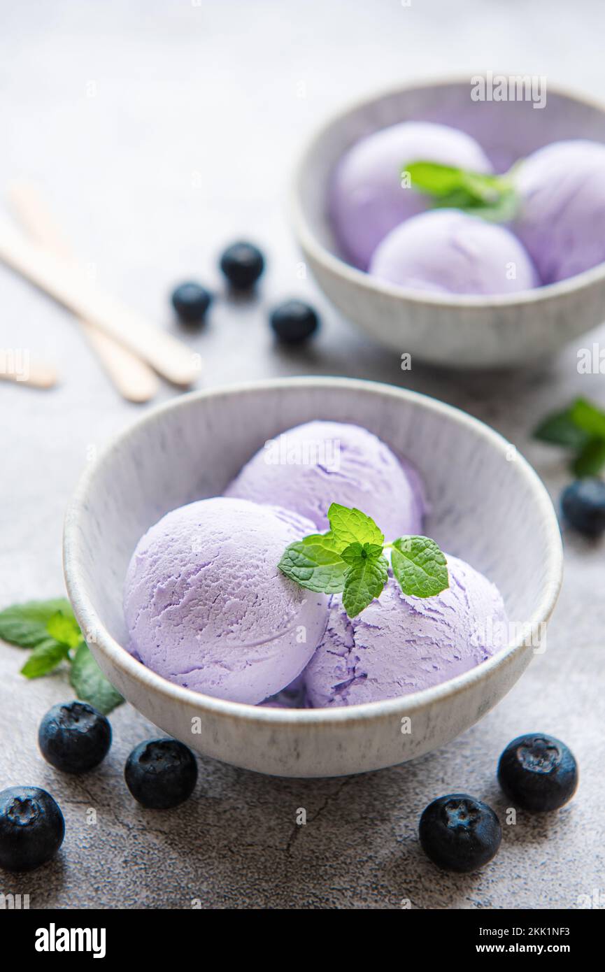 Gelato al mirtillo fatto in casa con mirtilli freschi. Dolce bacche dessert estate. Sfondo concreto Foto Stock