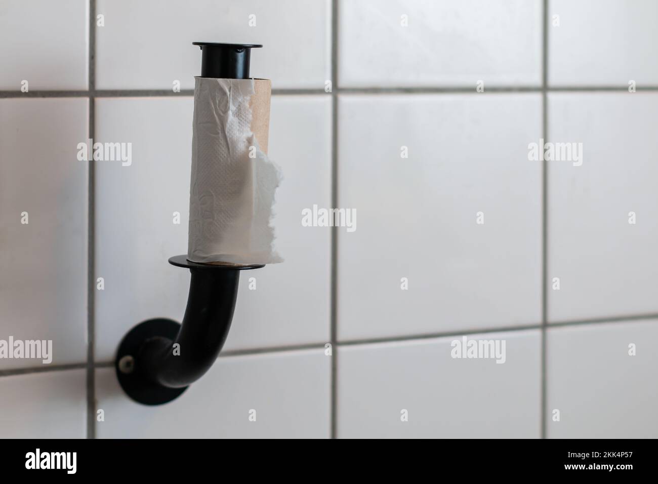 Carta igienica finita - rotolo vuoto di carta igienica montato su una parete piastrellata Foto Stock