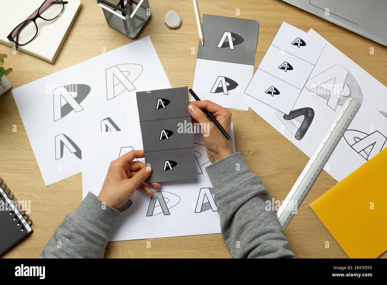 Un grafico sviluppa un logo per un marchio. L'illustratore disegna gli schizzi su carta. Foto Stock