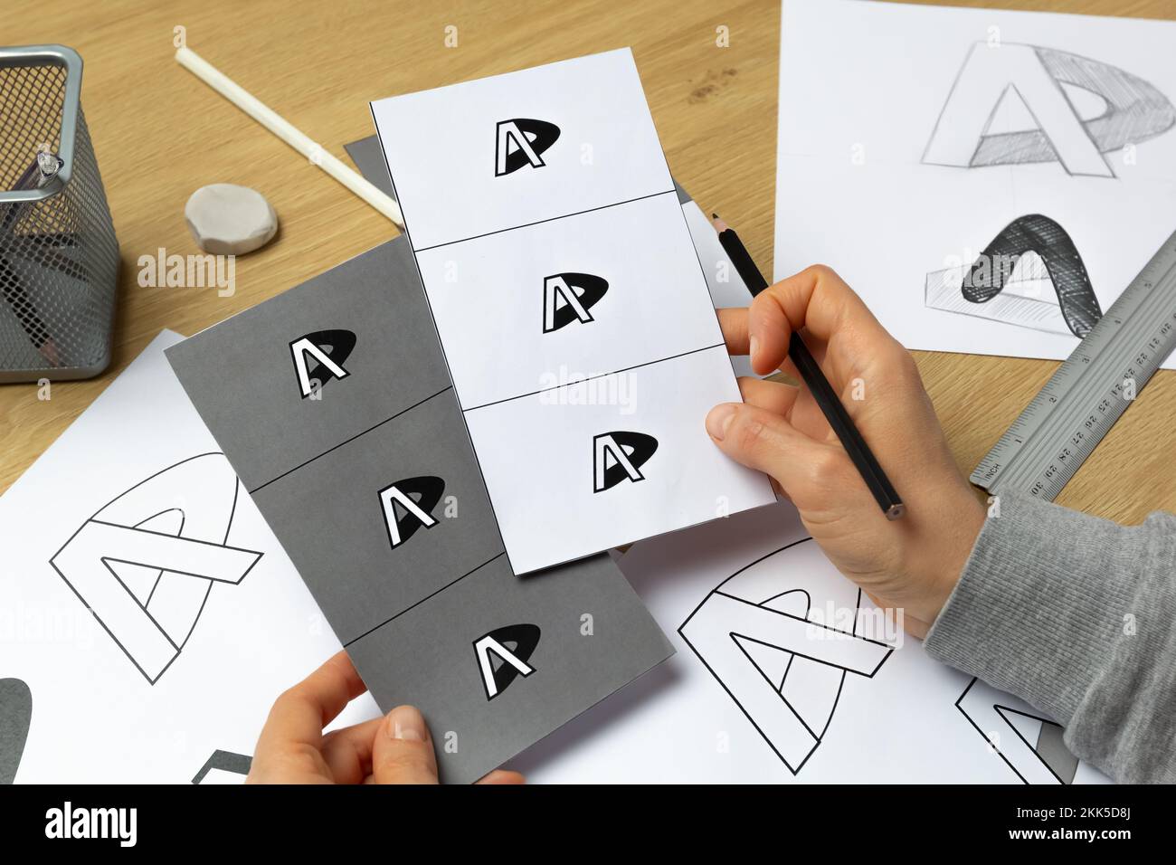 Un grafico sviluppa un logo per un marchio. L'illustratore disegna gli schizzi su carta. Foto Stock