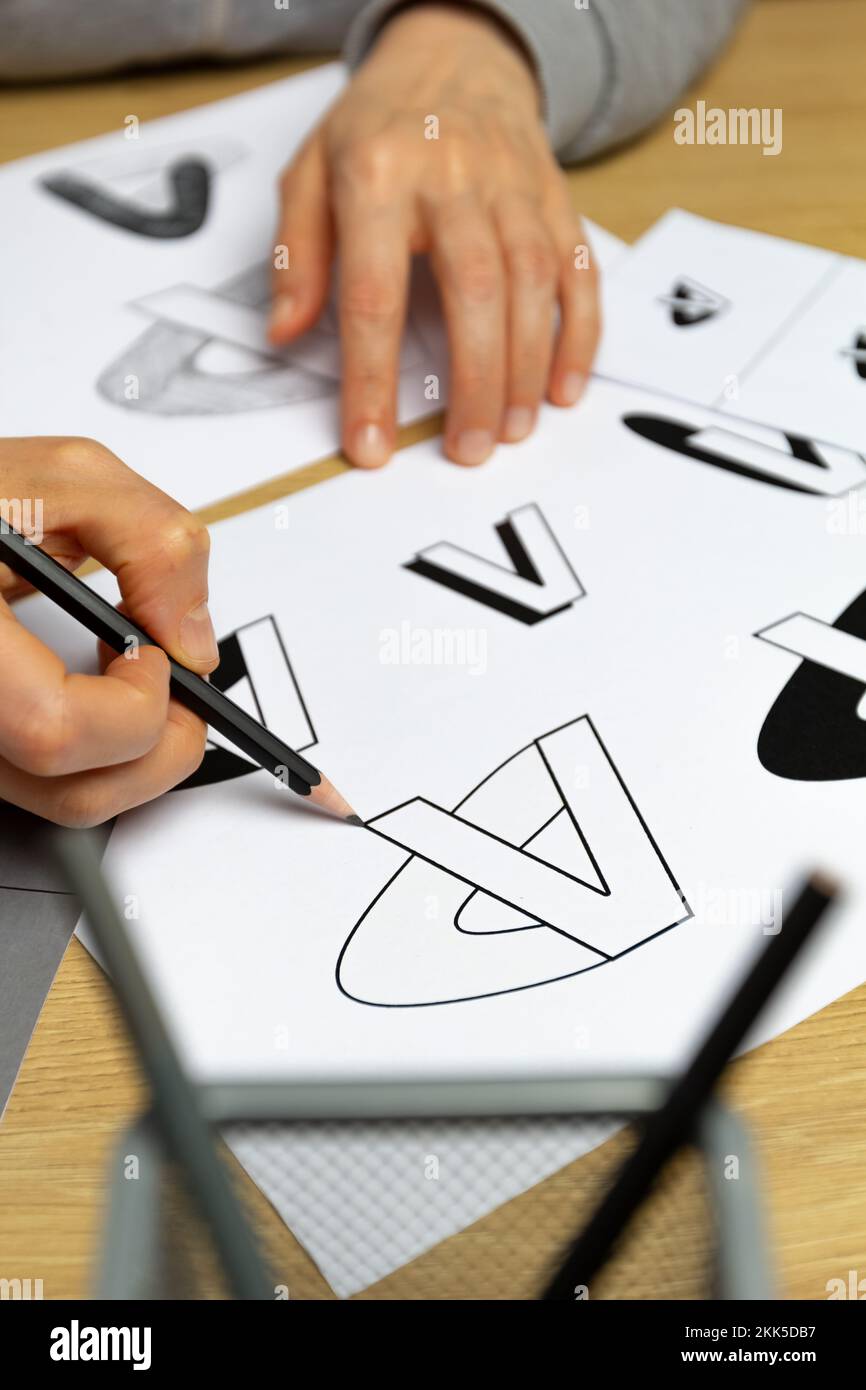 Un grafico sviluppa un logo per un marchio. L'illustratore disegna gli schizzi su carta. Foto Stock