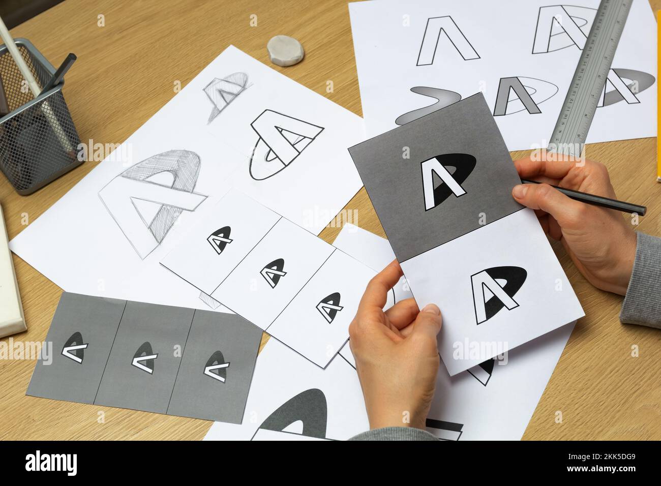 Un grafico sviluppa un logo per un marchio. L'illustratore disegna gli schizzi su carta. Foto Stock