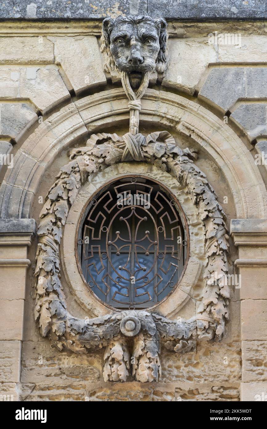 Vista dell'antica finestra con la testa del leone e decorazioni in pietra della ghirlanda nel giardino storico Promenade du Peyrou, Montpellier, Francia Foto Stock