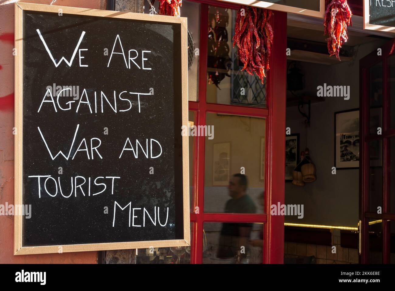 Siamo contrari alla guerra e al menu turistico. Concetto ironico messaggio di pace contro la guerra, su una lavagna, cartello fuori da un ristorante a Roma, Italia, Europa, UE. Foto Stock