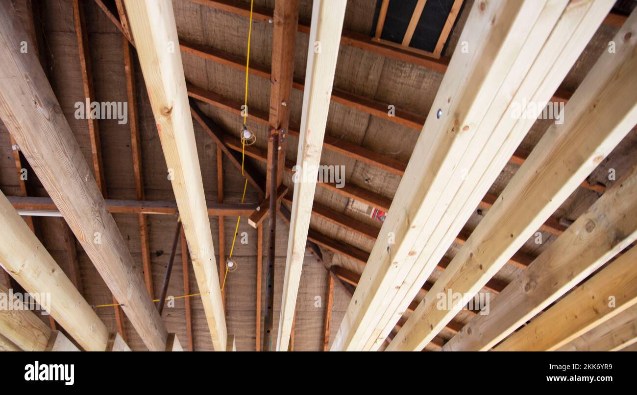 Vista interna di travi a soffitto in legno a vista e struttura in un edificio in costruzione o ristrutturazione Foto Stock