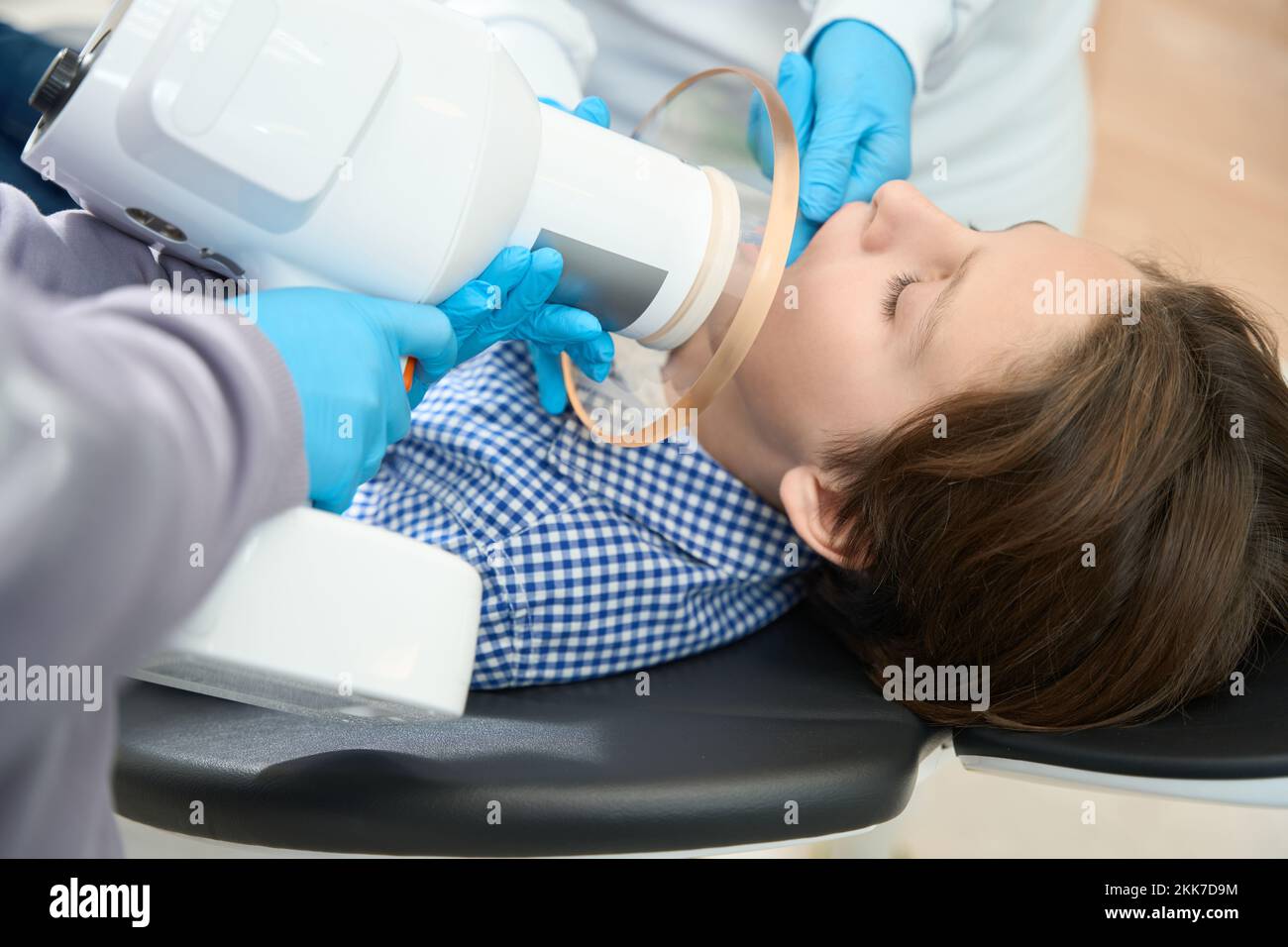 Al ragazzo viene data una radiografia del dente in studio dentale Foto Stock