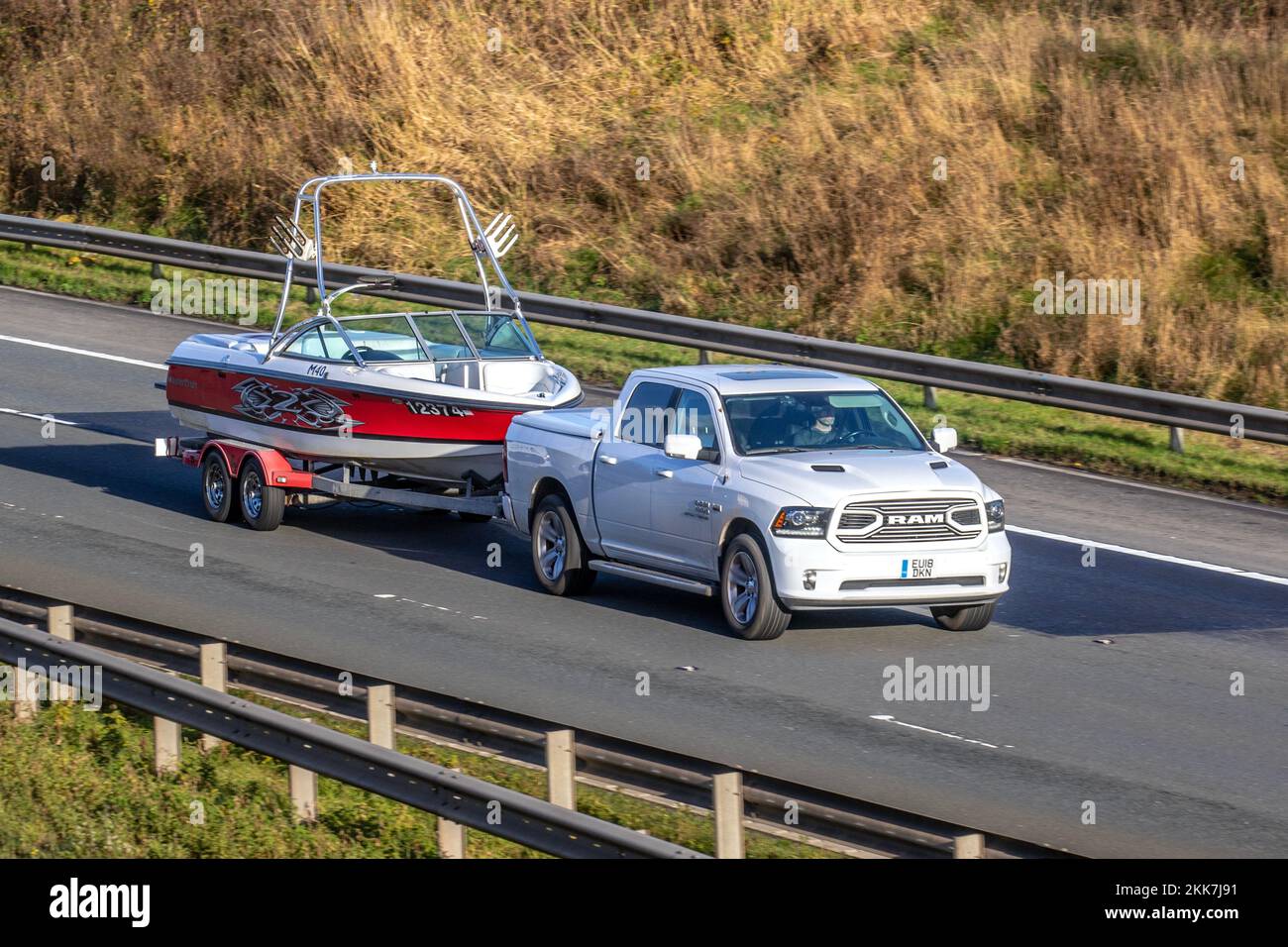 2018 American White Dodge RAM pick-up equipaggio cabina, con motore Hemi V8 da 5,7 litri. Traino Master Craft M40 X-barca a motore serie; viaggiando sull'autostrada M6, Regno Unito Foto Stock