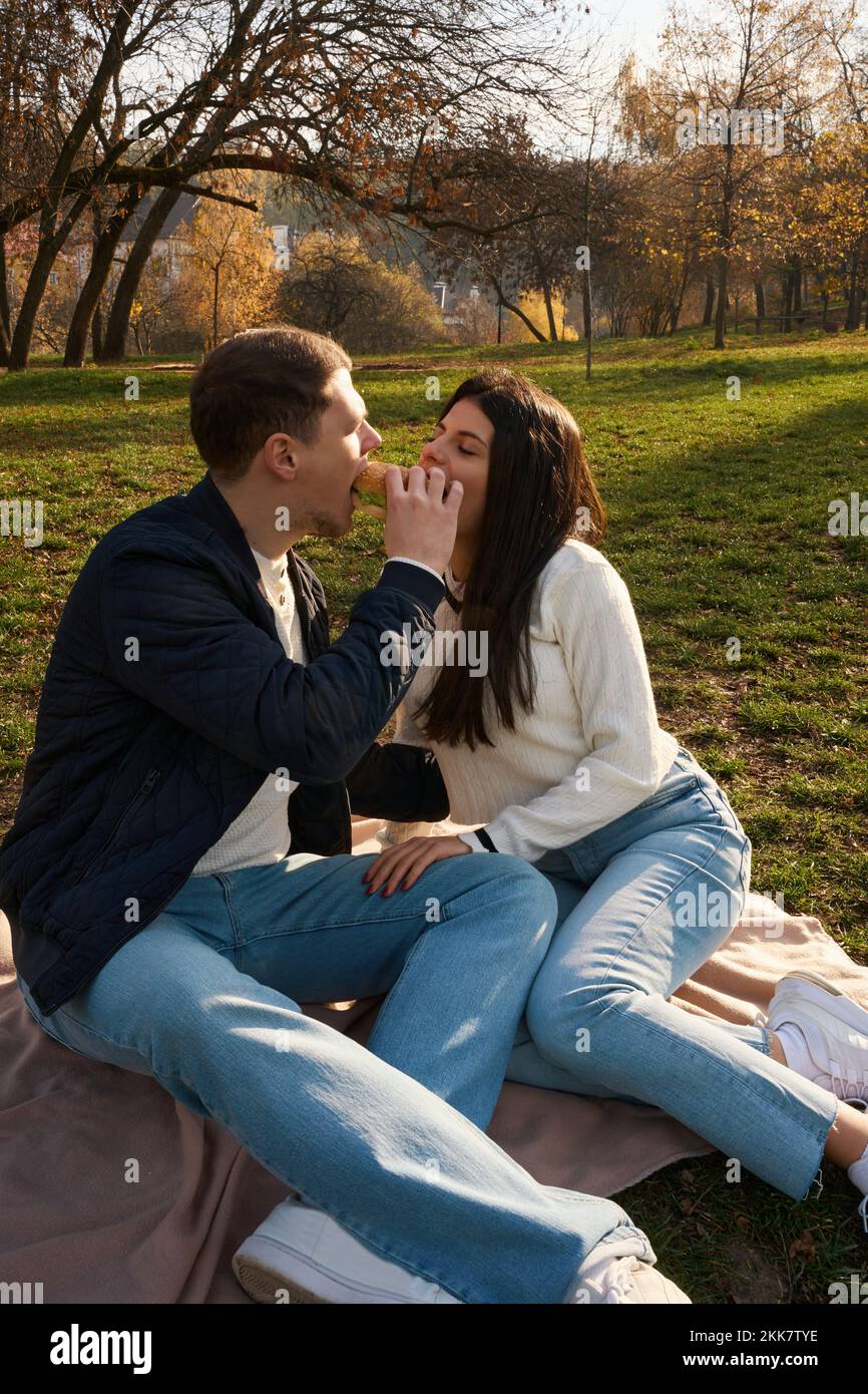 Allegra giovane coppia siede sul prato nel parco cittadino Foto Stock