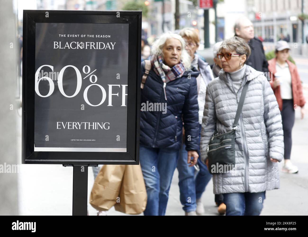 New York, Stati Uniti. 25th Nov 2022. Pedoni e acquirenti camminano da cartelli che pubblicizzano i prezzi di sconto sulla merce mentre camminano a Herald Square il Black Friday a New York City venerdì 25 novembre 2022. Per oltre un decennio, il Black Friday è stato tradizionalmente l'inizio ufficiale dell'affollato binge di acquisto racchiuso tra il giorno del Ringraziamento e Natale. Foto di John Angelillo/UPI Credit: UPI/Alamy Live News Foto Stock