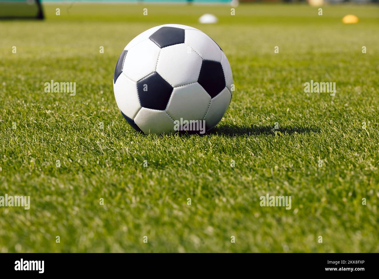 Classica palla da calcio su campo d'erba. Vista laterale sulla classica palla da calcio retrò. Immagine dello sfondo del calcio sportivo Foto Stock