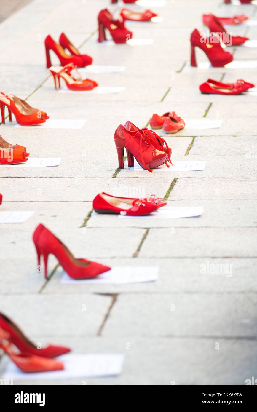 L'Italia, Lombardia, esposta scarpe rosso lungo la strada simboleggiava la ribellione contro la violenza sulle donne Foto Stock