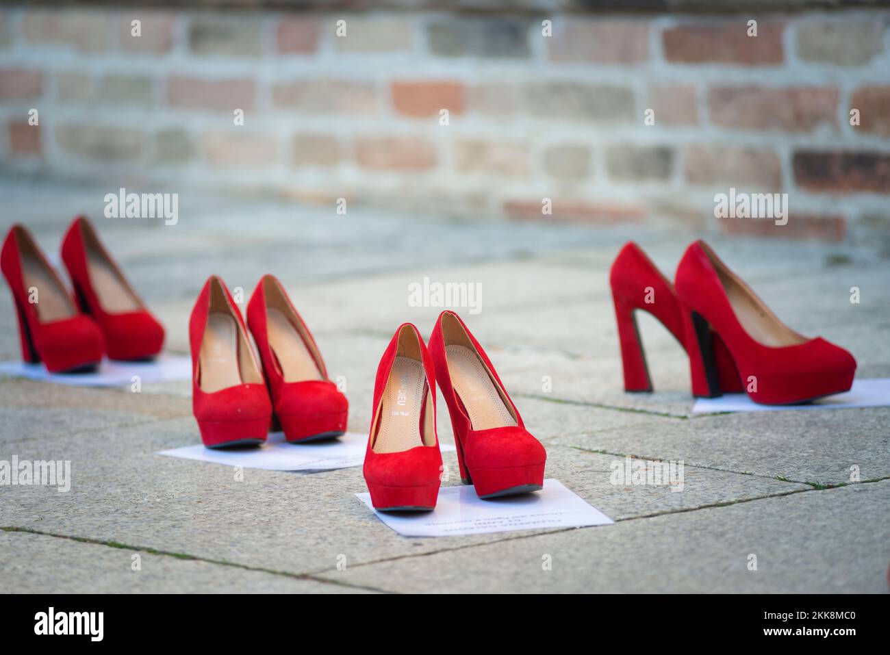 L'Italia, Lombardia, esposta scarpe rosso lungo la strada simboleggiava la ribellione contro la violenza sulle donne Foto Stock