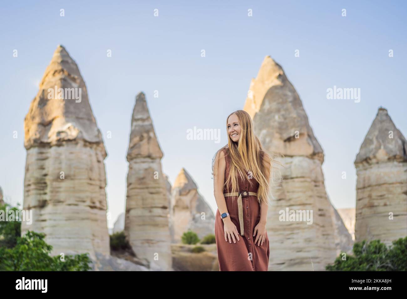 Donna turistica sullo sfondo di formazioni geologiche uniche in Love Valley in Cappadocia, popolare destinazione di viaggio in Turchia Foto Stock