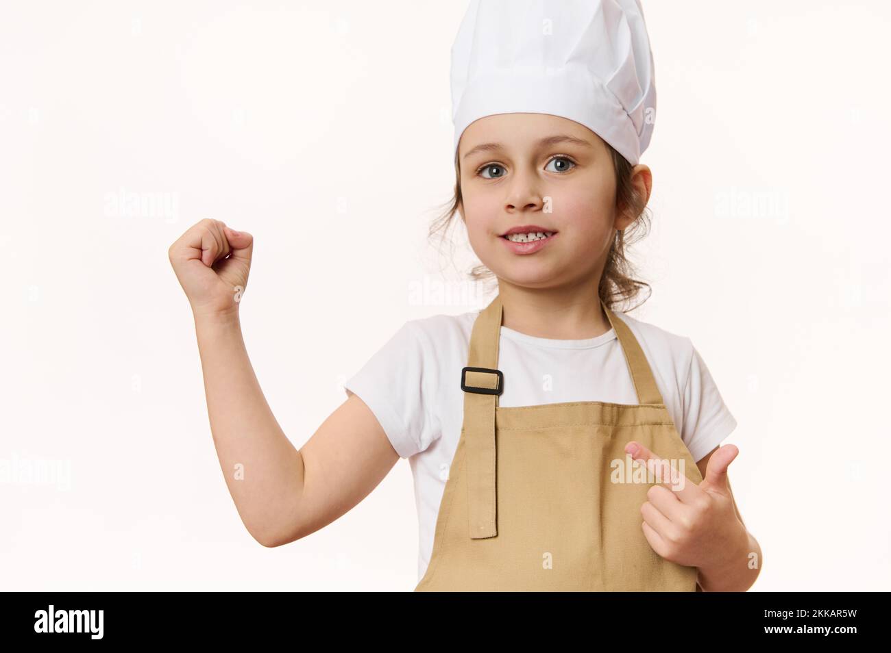Bella bambina - chef pasticceria in grembiule e cappello isolato su sfondo  bianco con spazio libero per il testo promozionale Foto stock - Alamy
