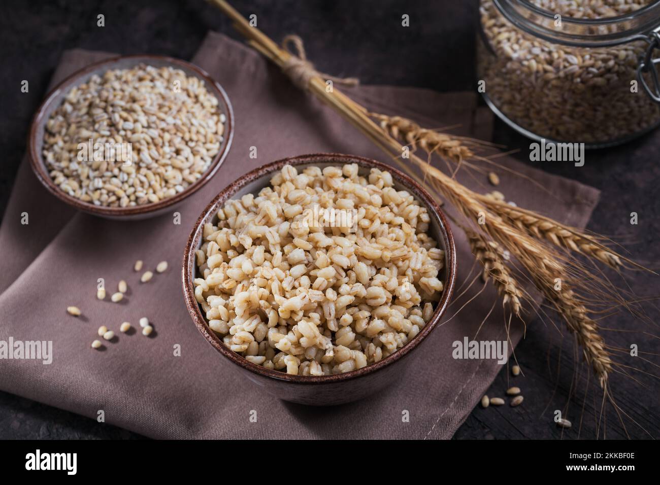 Ciotola di cereali d'orzo sbucciati cotti porridge con spighe di grano Foto Stock