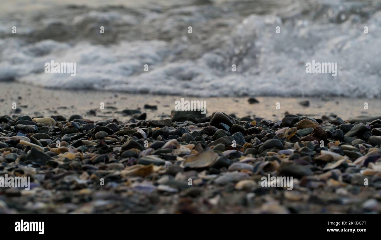 Ciottoli sulla spiaggia e sul mare. Concetto di copertina del libro. Foto della spiaggia. Messa a fuoco selettiva inclusa. Foto Stock