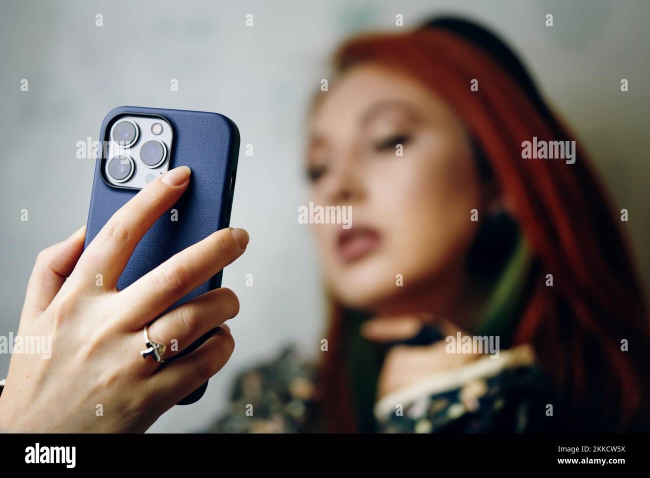 Red hair femmina prende selfie su iPhone 13 pro. Foto Stock