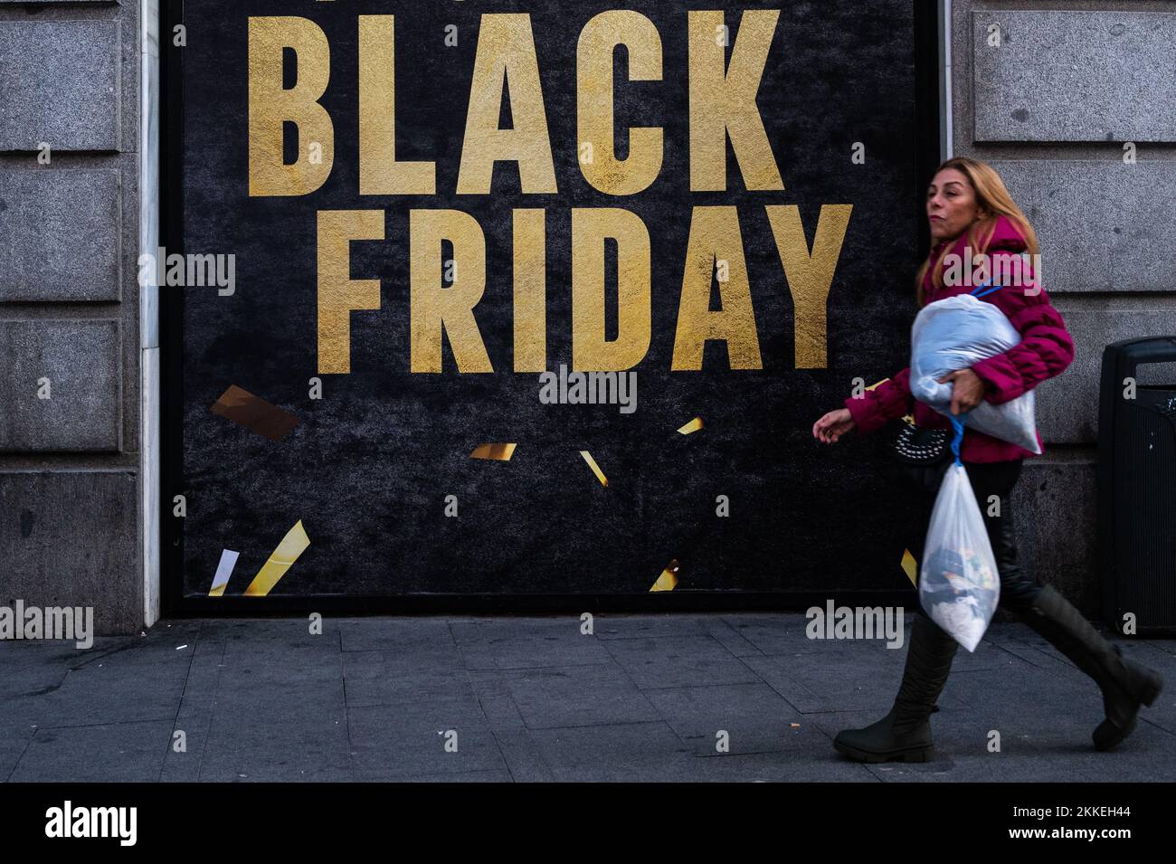 Madrid, Spagna. 25th Nov 2022. Una donna cammina passando da un cartello che annuncia uno sconto per il Black Friday sulla vetrina di un negozio nel centro di Madrid durante il Black Friday. Credit: Marcos del Mazo/Alamy Live News Foto Stock