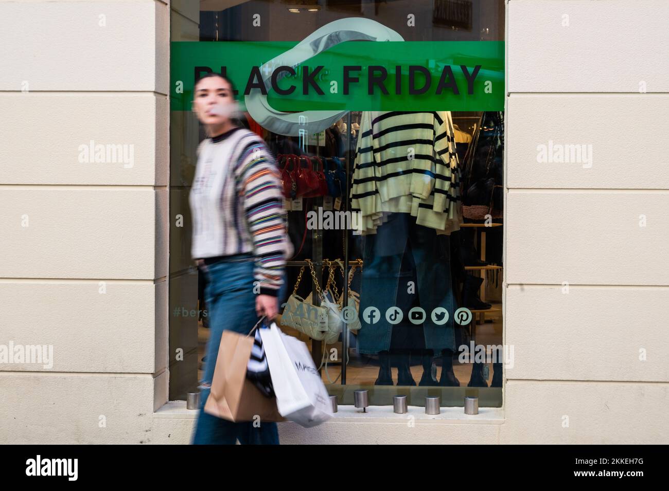 Madrid, Spagna. 25th Nov 2022. Una donna cammina passando da un cartello che annuncia uno sconto per il Black Friday sulla vetrina di un negozio nel centro di Madrid durante il Black Friday. Credit: Marcos del Mazo/Alamy Live News Foto Stock