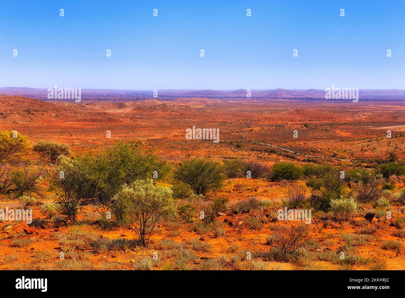 Paesaggio panoramico di terra rosso arido e luminoso del deserto australiano dell'entroterra intorno alla città di Broken Hill nel New South Wales in una calda giornata estiva. Foto Stock