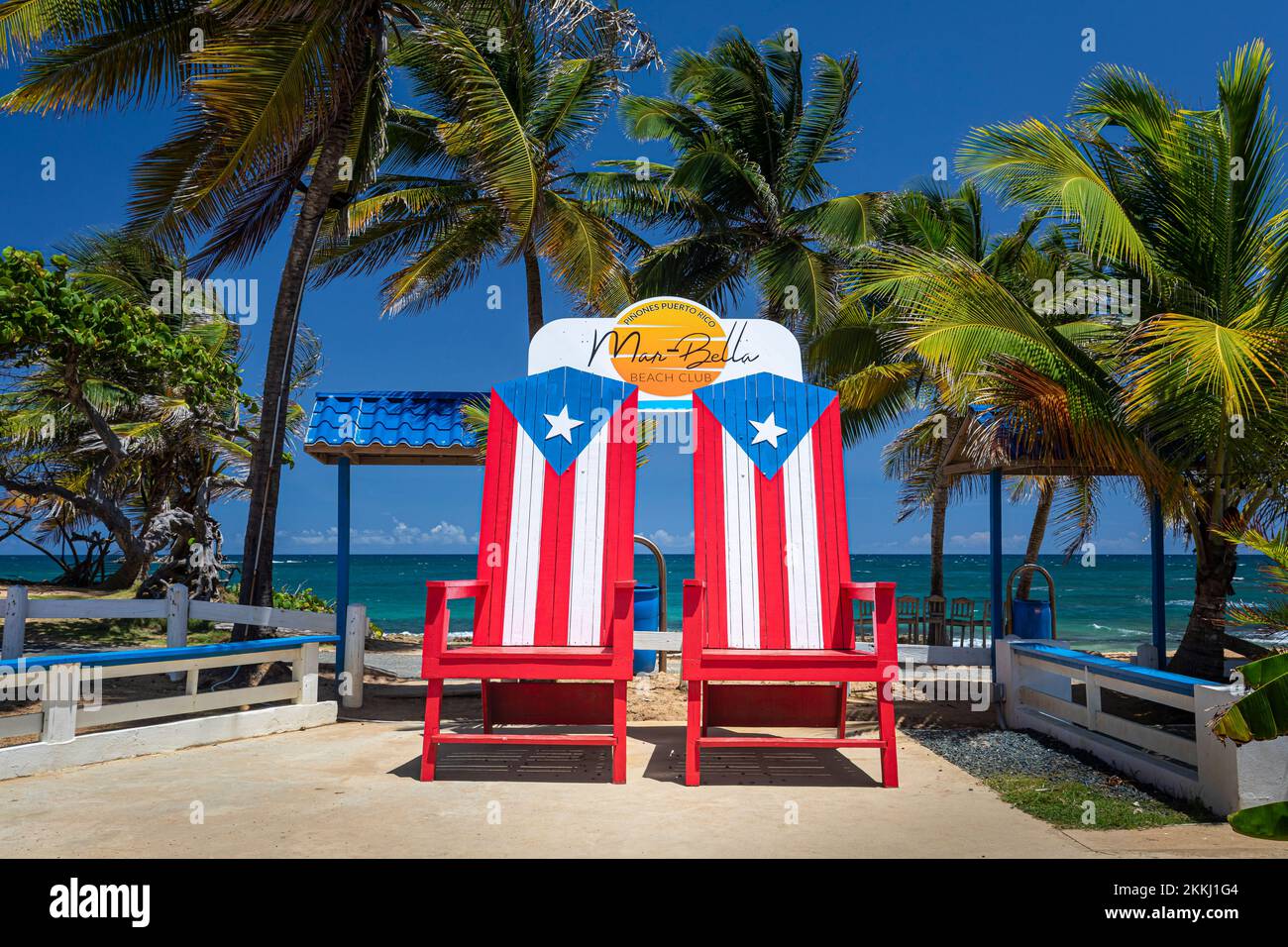 Grandi sedie dipinte come la bandiera portoricana a Piñones Beach vicino Carolina, sull'isola tropicale dei Caraibi di Puerto Rico, USA. Foto Stock