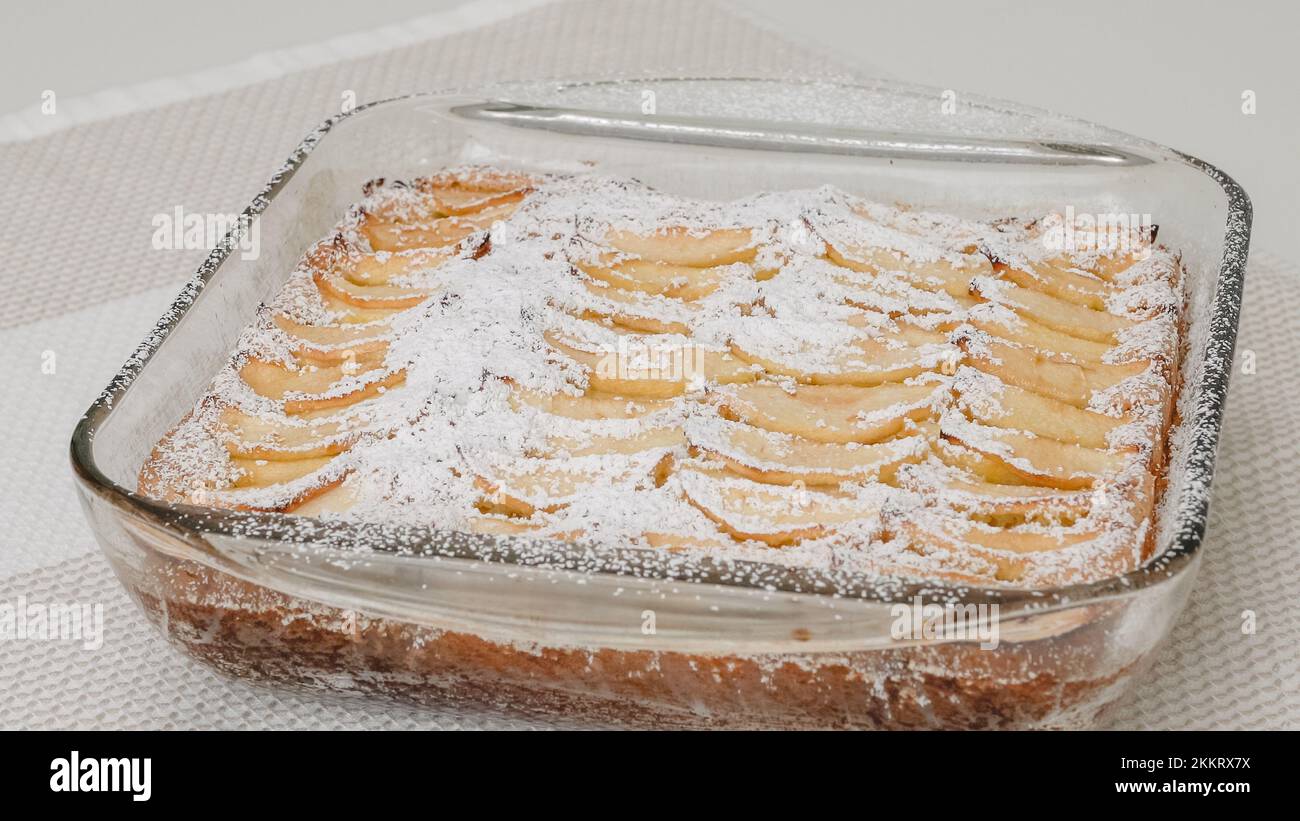 Torta di mele appena sfornata con biscotto a base ravvicinata sul tavolo da cucina, appena dal forno. Torta di condimenti con zucchero a velo. Foto Stock