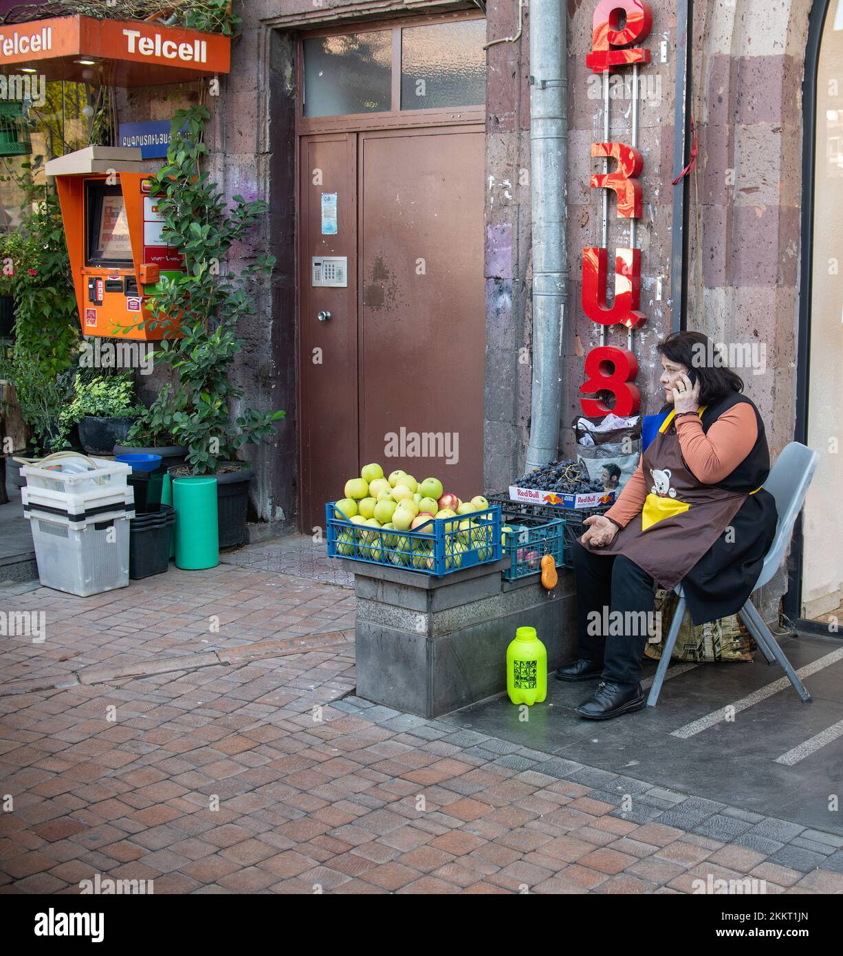 Un venditore di frutta femminile sul marciapiede a Yerevan, Armenia Foto Stock