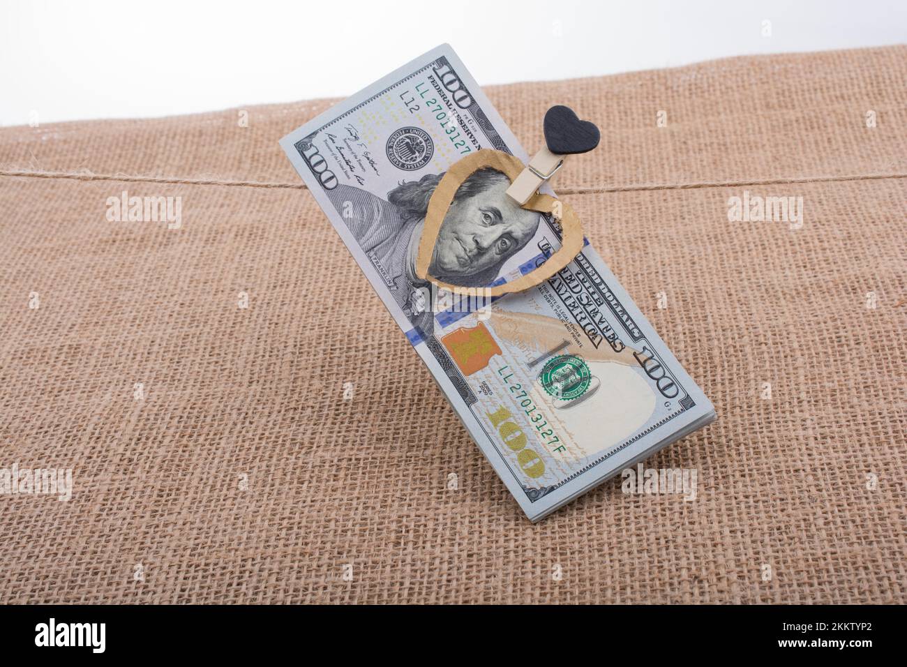 American 100 banconote di dollari con un cuore agganciare una stringa Foto Stock