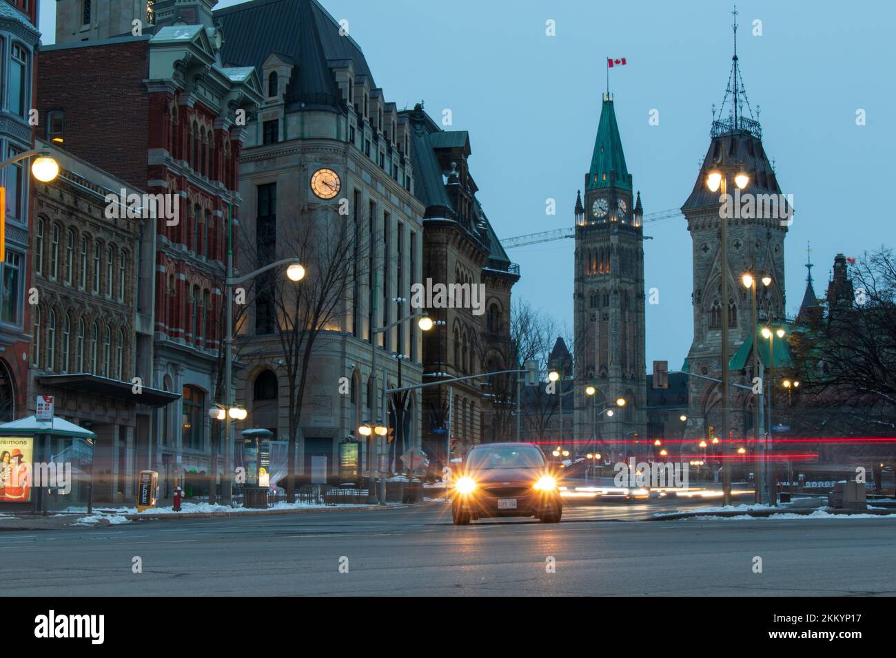 Il traffico cittadino passa nel tardo pomeriggio nel centro di Ottawa. Parliament Hill è visto in lontanità sullo sfondo della capitale del Canada. Foto Stock