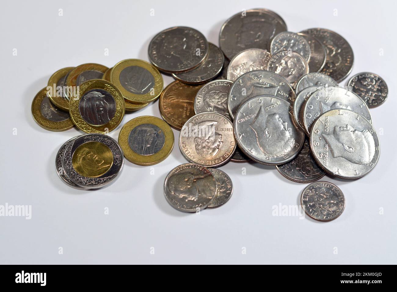Pile di monete saudite e americane di 1, 2 SAR uno e due riyals, mezzo dollaro 50 centesimi, 25 centesimi quarti, dime 10 centesimi e cinque centesimi, USA An Foto Stock
