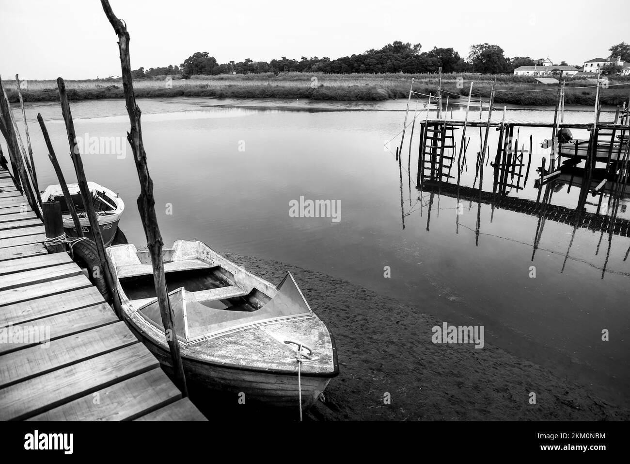 Vecchie barche da pesca ormeggiate in un porto con una passerella in legno a Carrasqueira, Portogallo Foto Stock