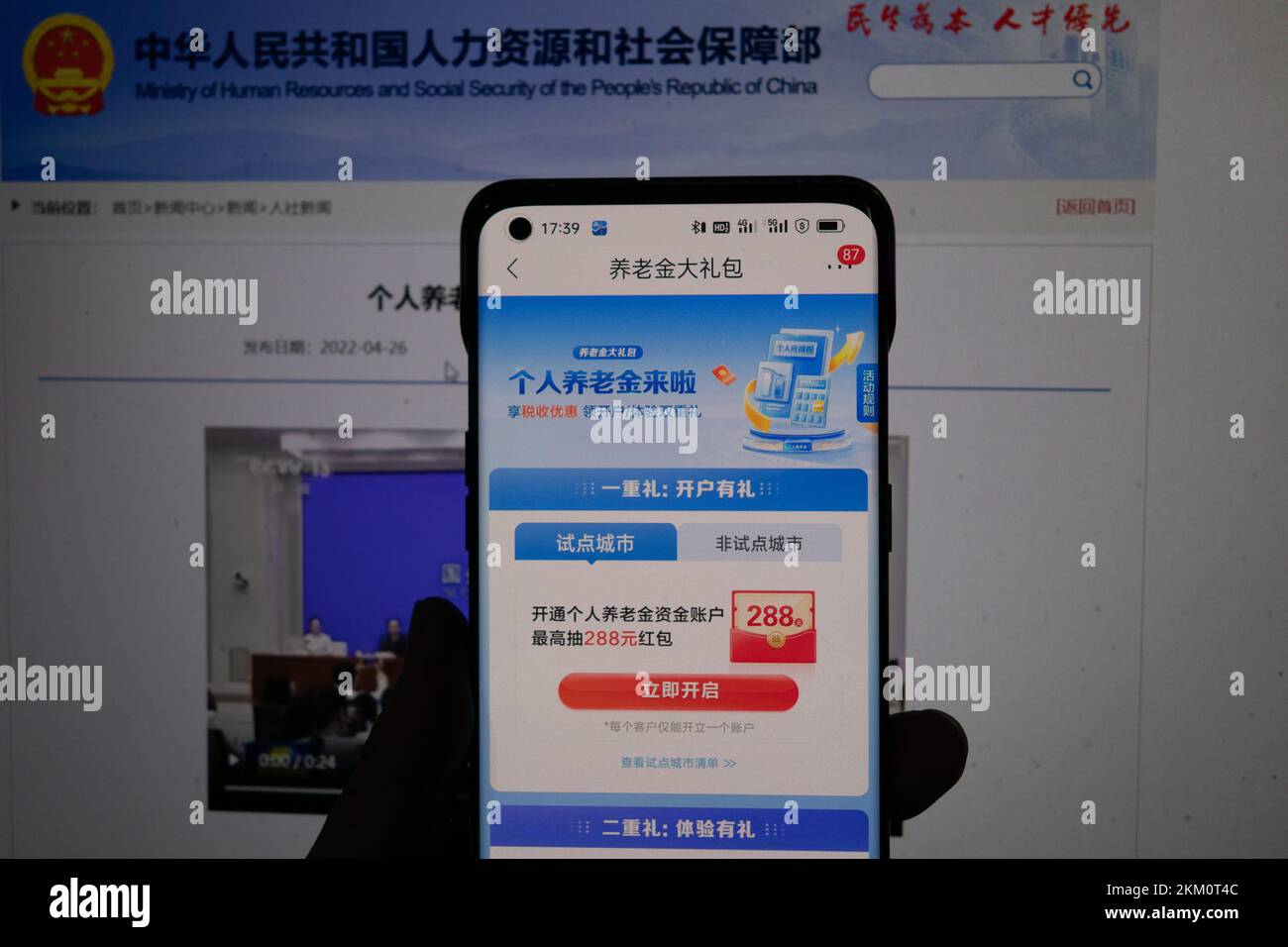 Un cittadino controlla le informazioni sulla sua pensione personale tramite il suo telefono cellulare e il computer a Shanghai, Cina, 26 novembre 2022. Il Ministero del resto umano Foto Stock