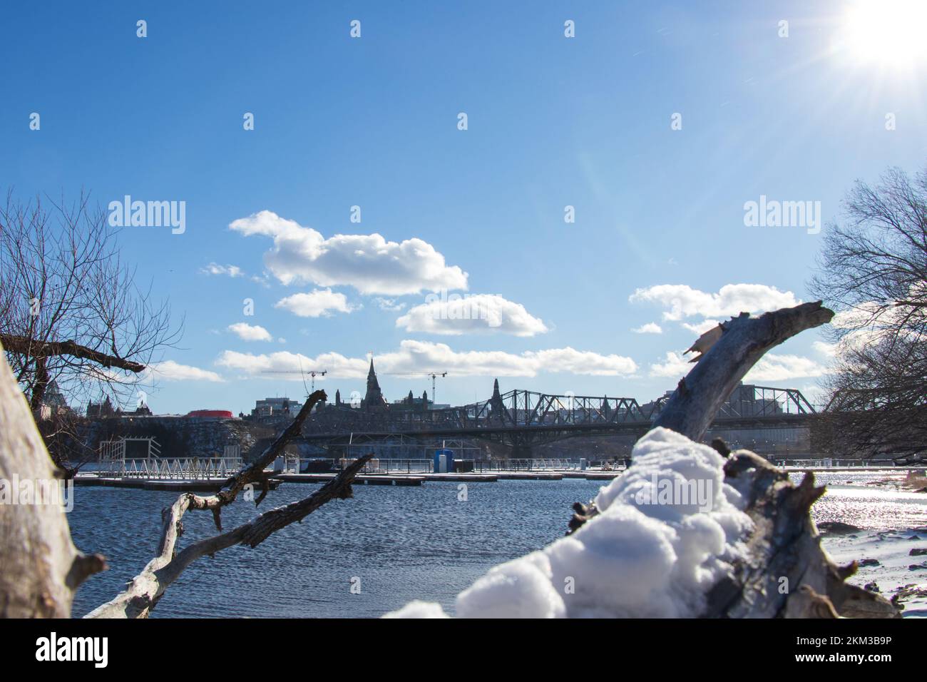 Il sole di mezza giornata splende sul grandangolo di uno skyline innevato della città di Ottawa, Parliament Hill è visto in lontano sfondo dal Quebec. Foto Stock