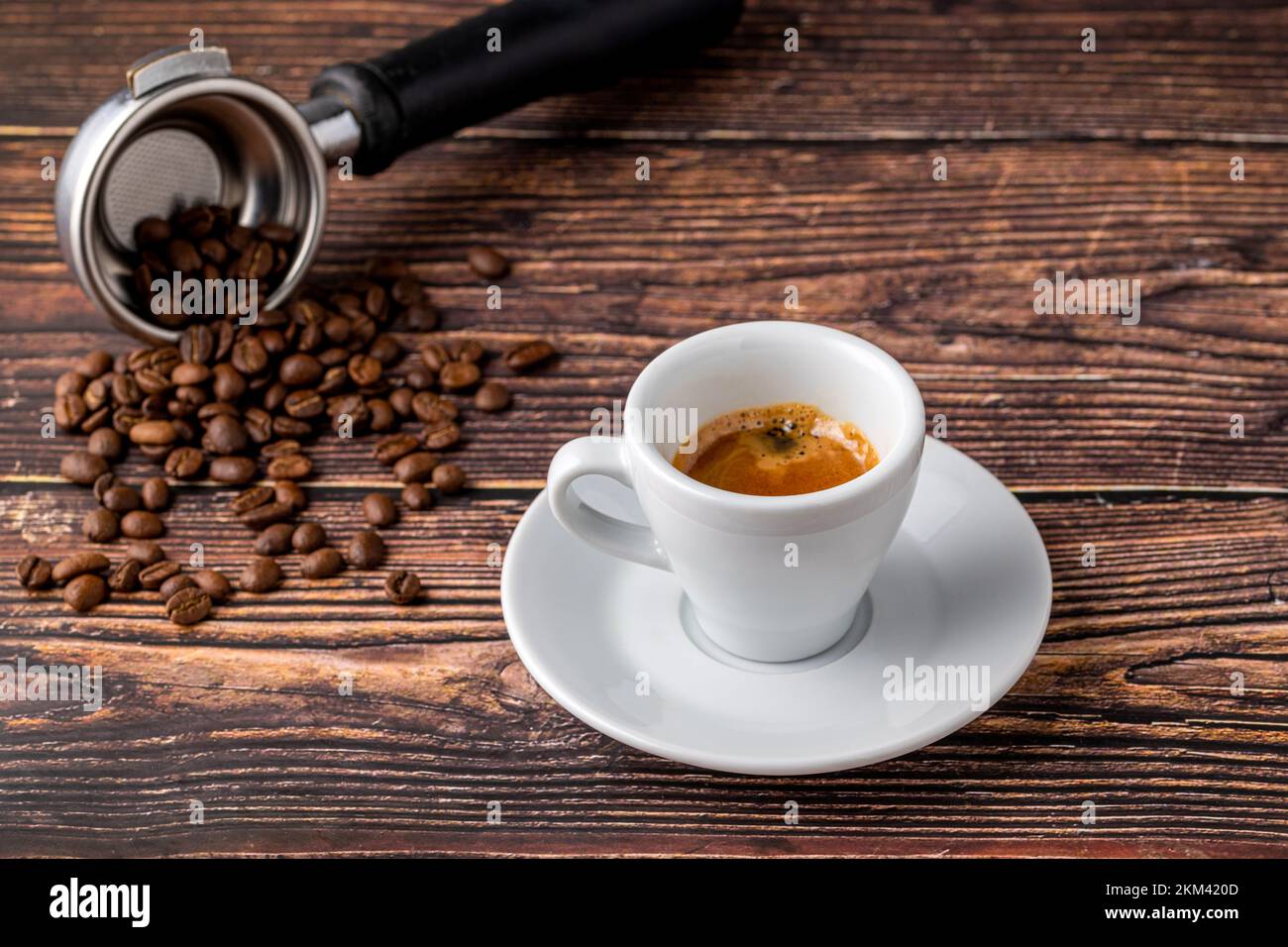 Caffè espresso fresco e decorato con chicchi di caffè su un tavolo di legno Foto Stock