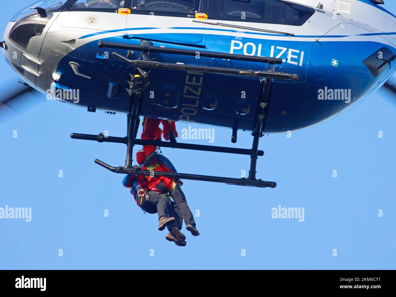 Ballenstedt, Germania. 26th Nov 2022. Un elicottero di polizia porta un membro della squadra di salvataggio di montagna Harz con un verricello sopra il massiccio di montagna sul Gegensteinen. I 20 membri di Bergwacht, addestrati al salvataggio aereo, devono mettere regolarmente in pratica le loro conoscenze teoriche. In totale, questo è il quarto giorno di esercizio con la polizia. Credit: Matthias Bein/dpa/Alamy Live News Foto Stock