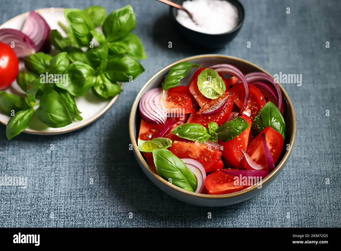 Insalata succosa con pomodori, basilico e cipolla blu. Foto Stock