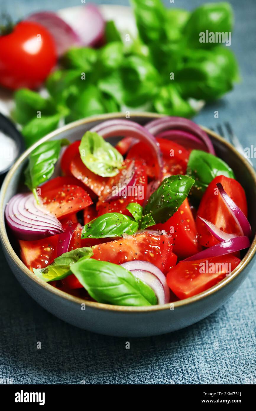 Insalata succosa con pomodori, basilico e cipolla blu. Foto Stock