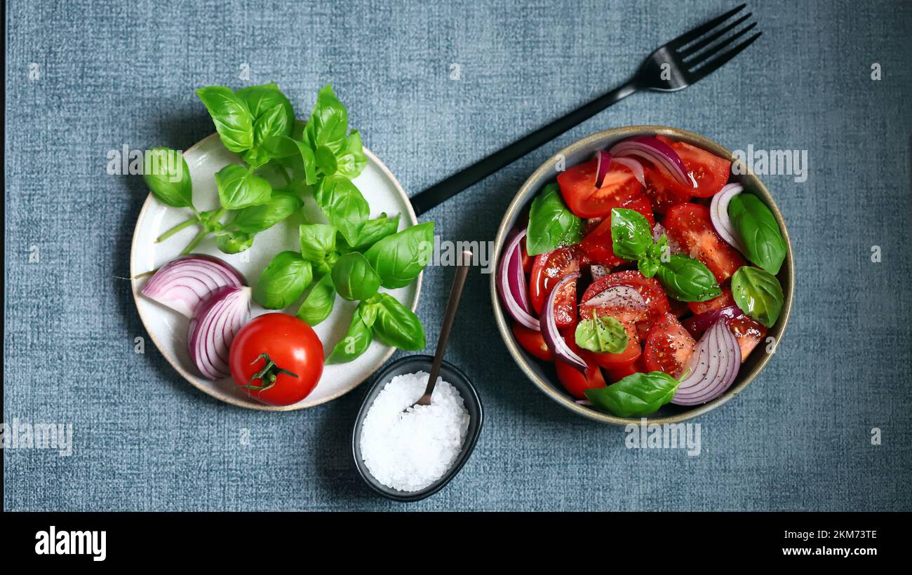 Insalata succosa con pomodori, basilico e cipolla blu. Foto Stock