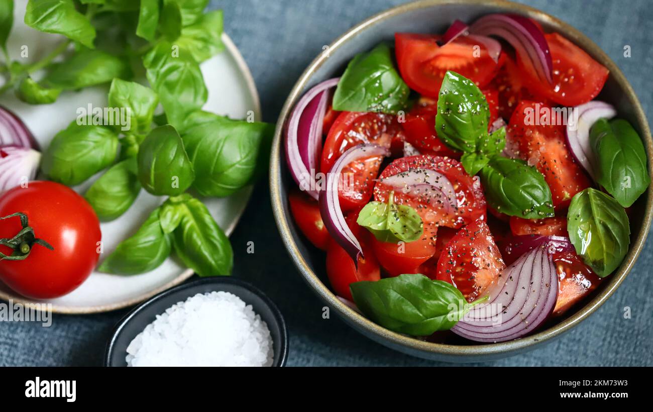 Insalata succosa con pomodori, basilico e cipolla blu. Foto Stock