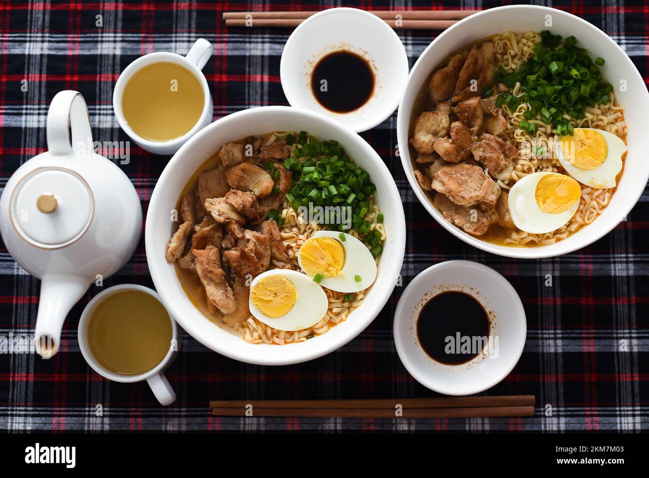 Ramen giapponese con pollo e salsa di soia sul tavolo con teiera e tè verde Foto Stock