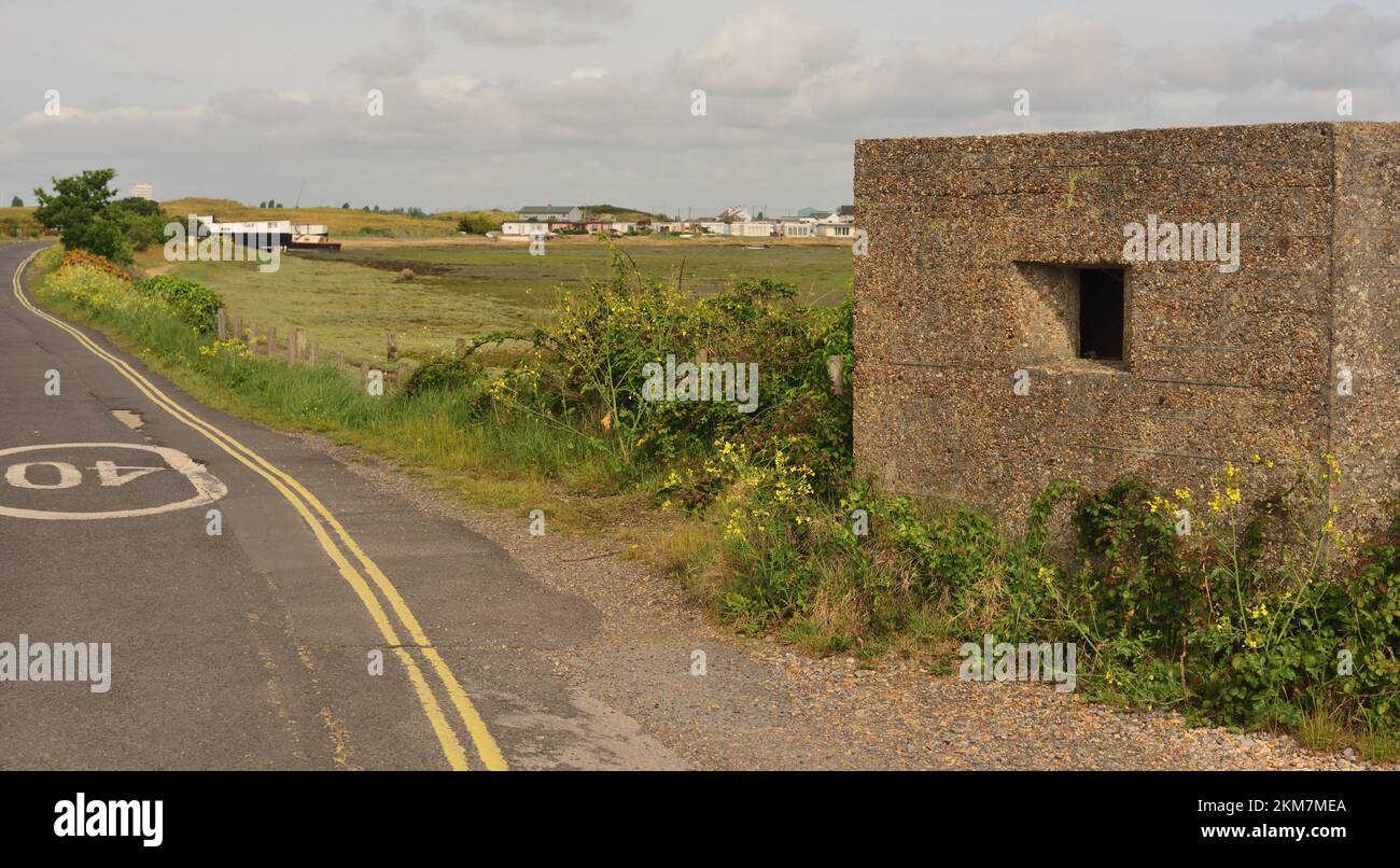 Un vecchio pillbox in tempo di guerra al Kench sull'Isola di Hayling, con case galleggianti sullo sfondo. Foto Stock