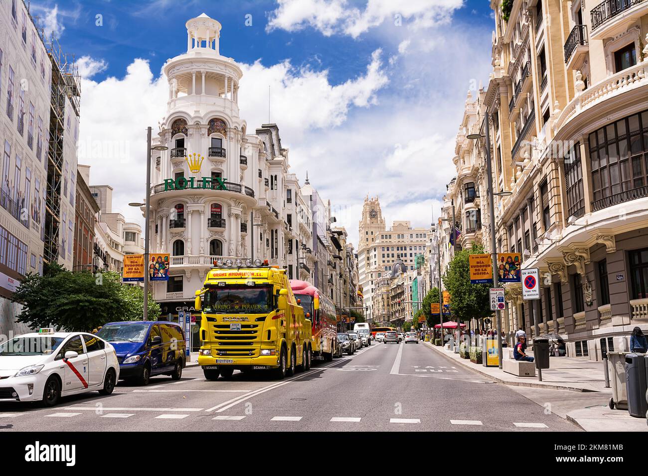 Madrid, Spagna - 20 giugno 2022: Inizio della Gran Via con camion e traffico al semaforo e sulla sinistra l'edificio erboso, Madrid Foto Stock