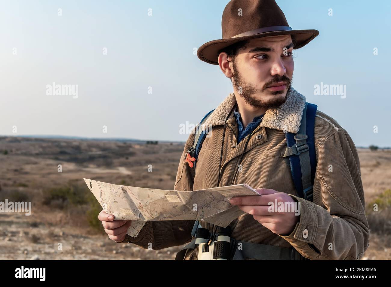 Un primo piano di un escursionista maschio utilizzando una mappa per individuare la destinazione Foto Stock