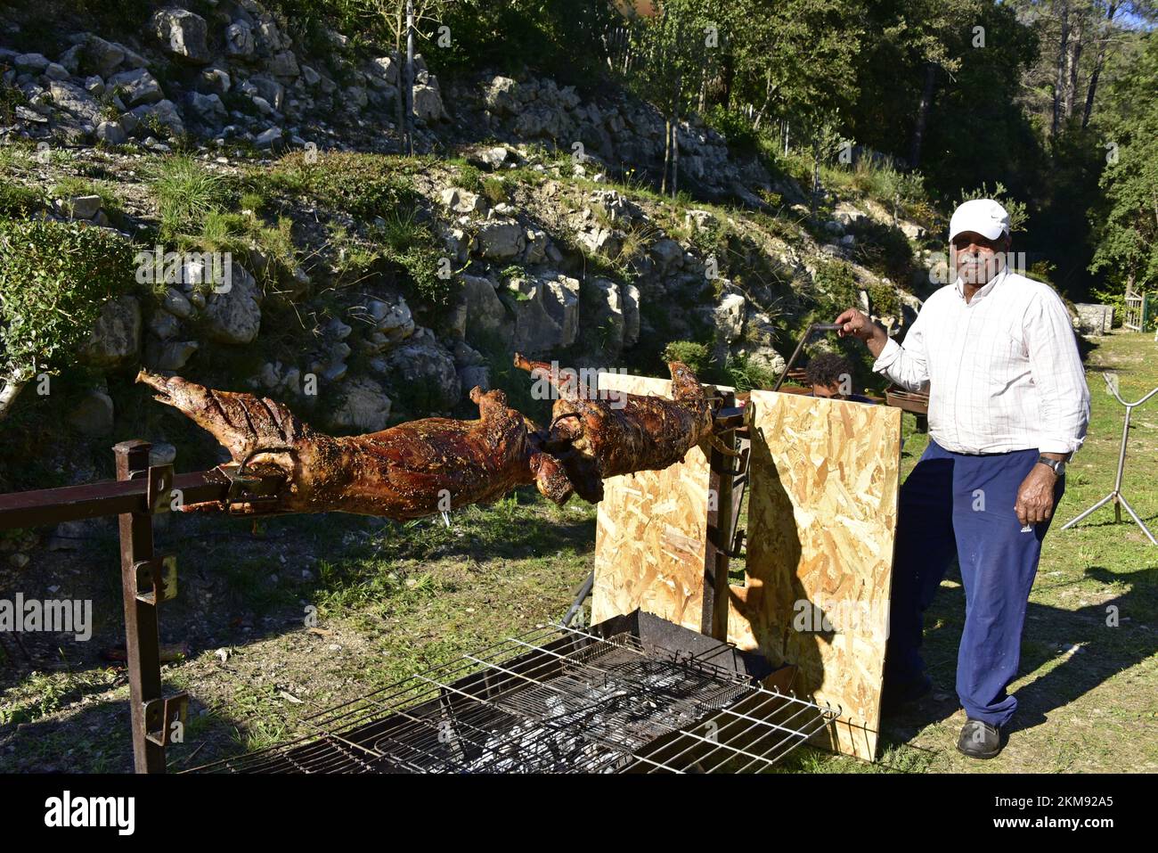 Preparazione da parte dell'operatore di mouton farcito di couscous per arrostire su uno spiedo in mechoui Foto Stock