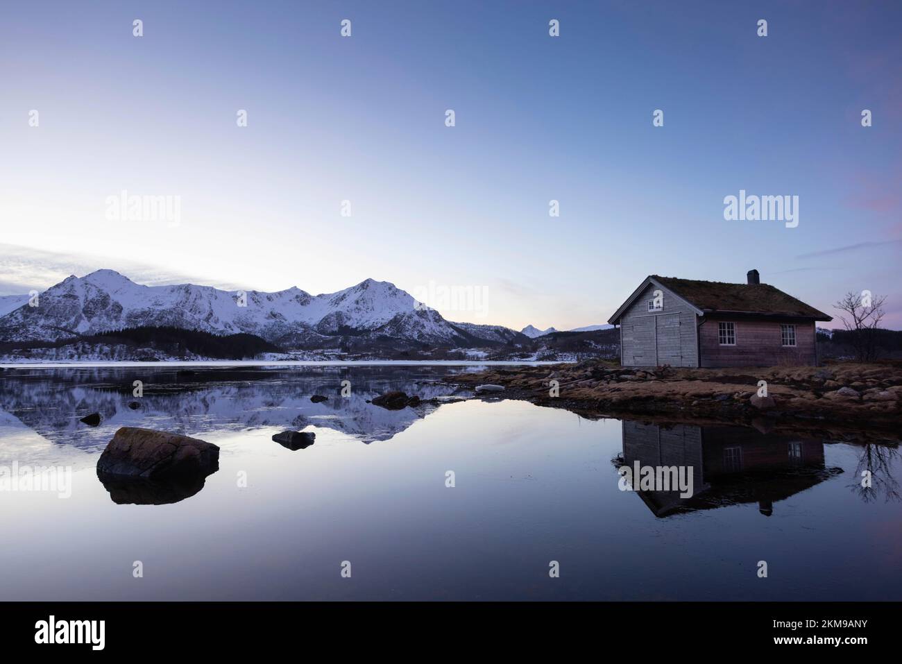Cabina riflesso in un lago calmo al crepuscolo Foto Stock