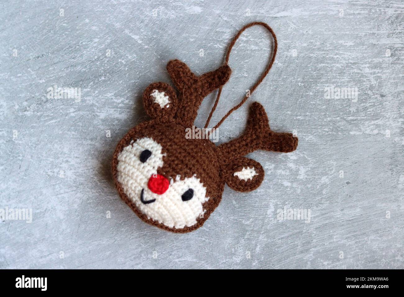 Cute mano fatto ornamento di Natale. Foto ravvicinata delle renne a crochet. Idee regalo invernali accoglienti. Foto Stock