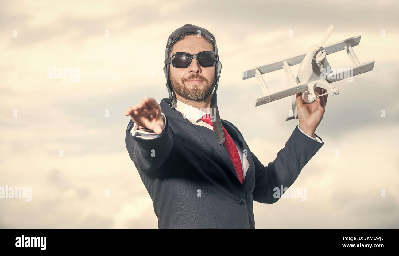 uomo d'affari in abito e cappello pilota lancia giocattolo aereo. ispirazione Foto Stock